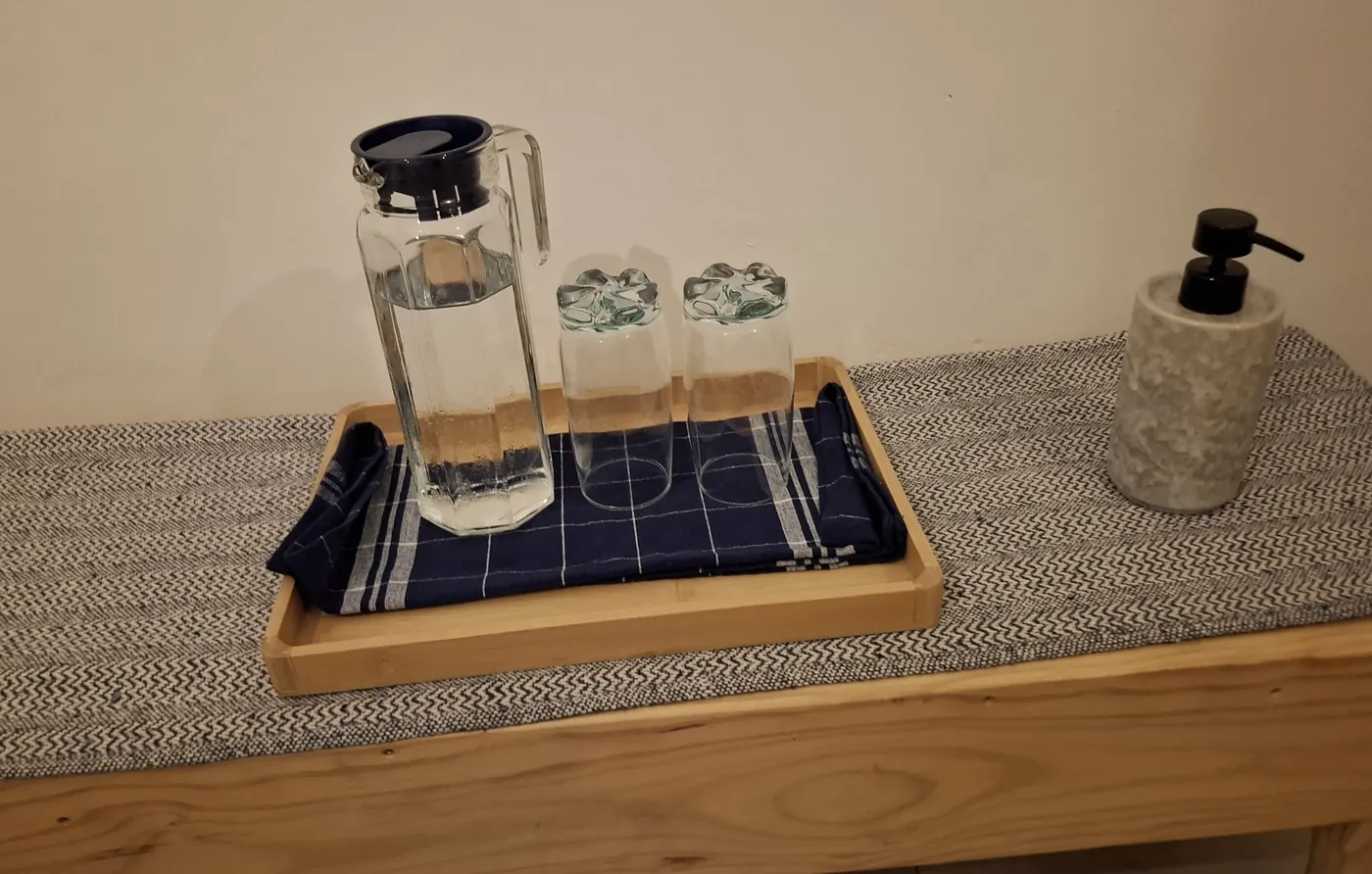 Filtered water and glasses set out on a pine bench before a session